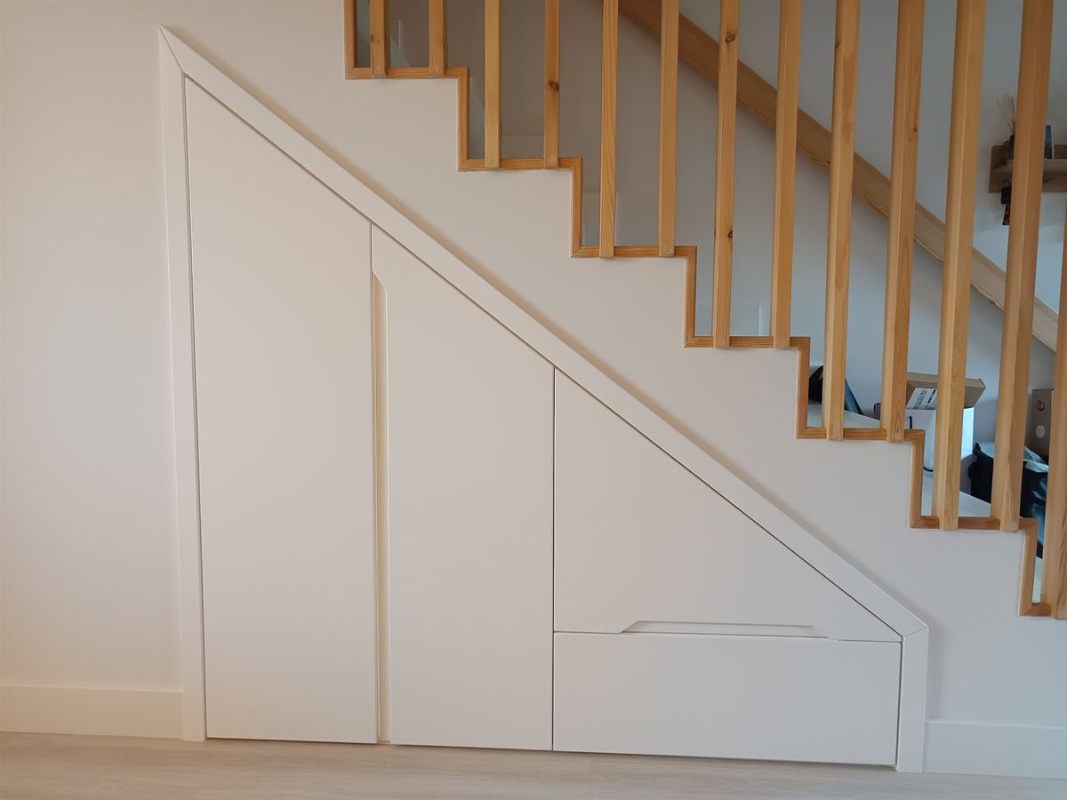 Armario bajo escalera. Almacenaje adaptado a la pendiente de la escalera.