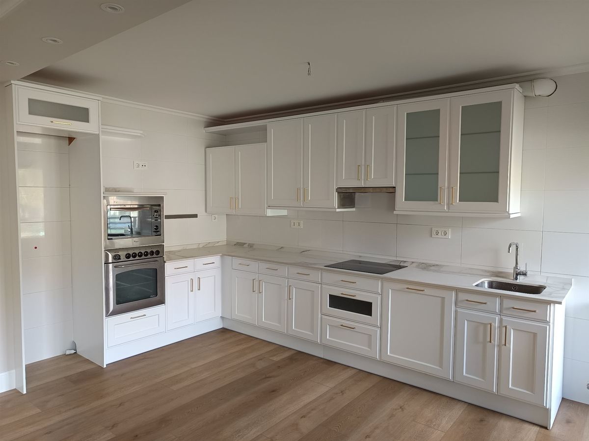Cocina de líneas clásicas. Conjunto de mobiliario de cocina con frentes claros.