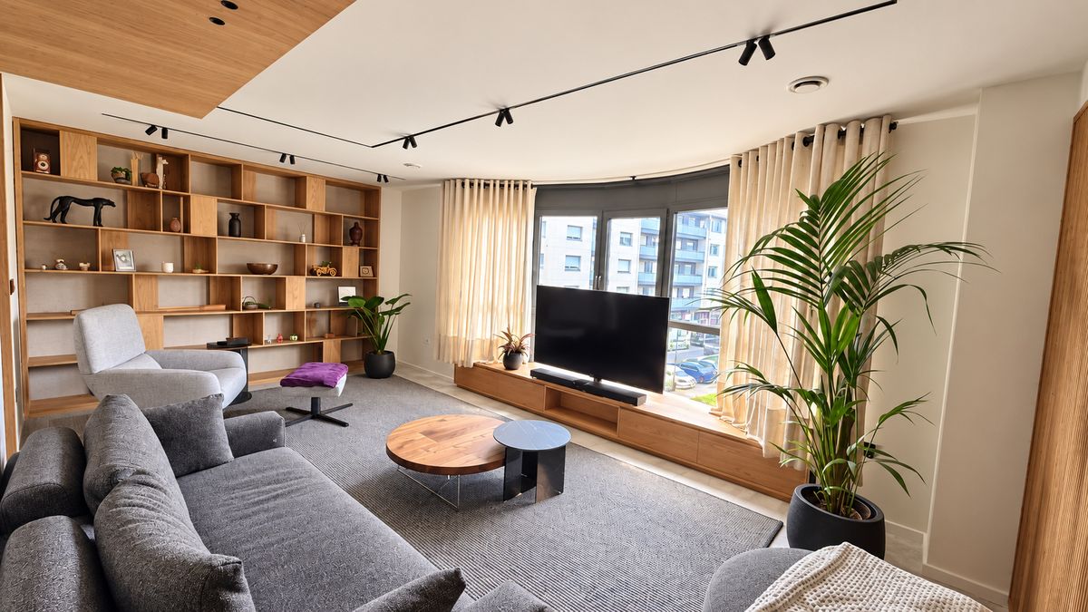 Oak living room. Wall bookcase, low TV unit under the window and wood-clad ceiling.