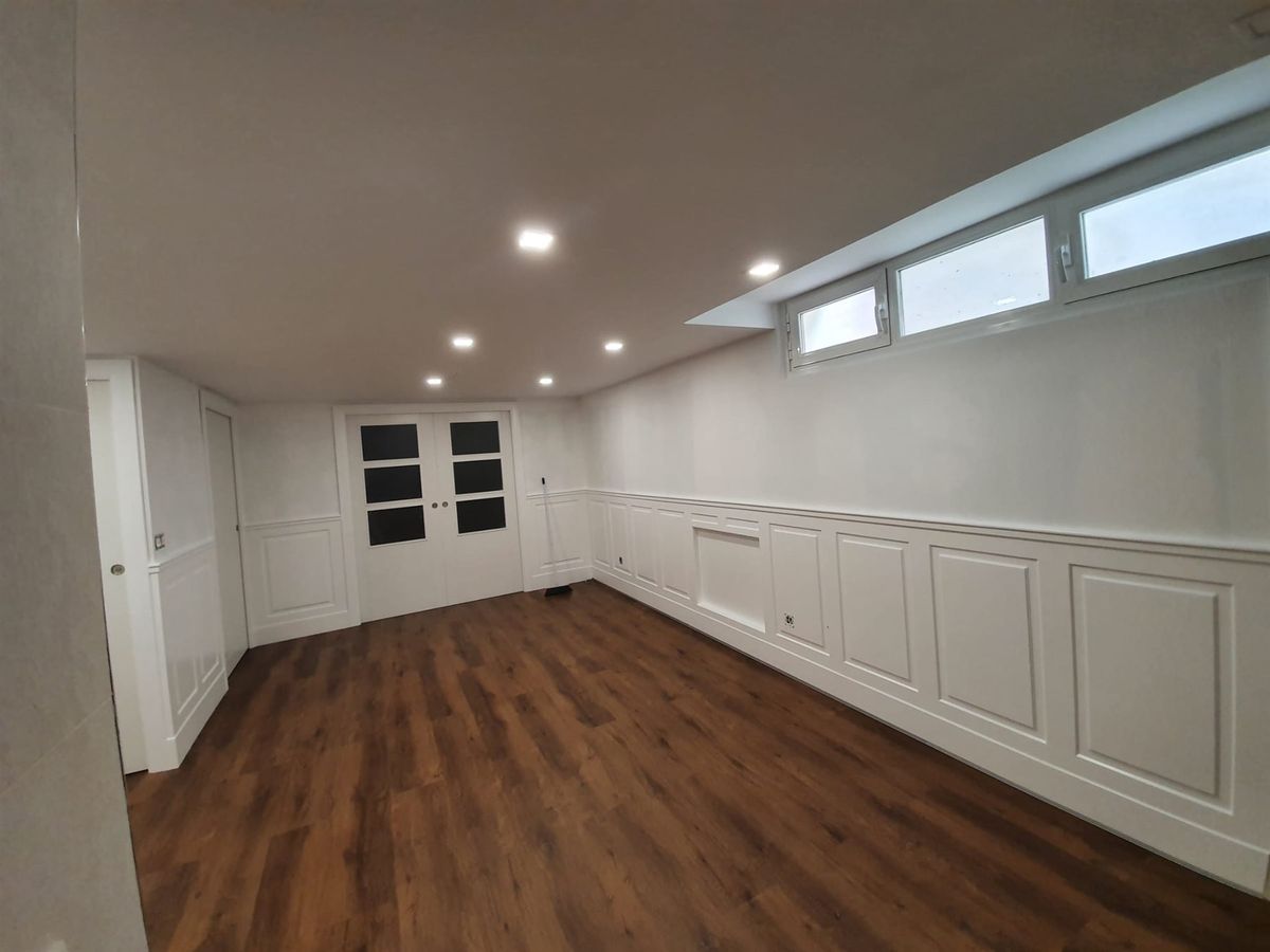 Suelo y revestimiento interior. Vista de una estancia con suelo y panelado de pared.