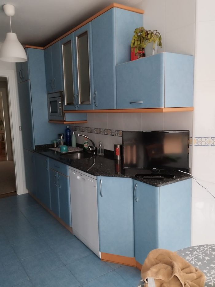 Înainte: chiuvetă cu mobilier albastru și blat închis.